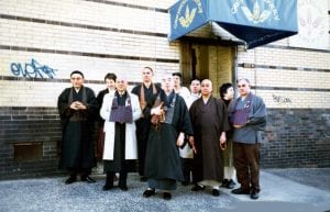 Image shows the founders of Greyston Bakery posing in front of the bakery awning.