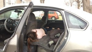 Through an open car door, two sleeping children are visible