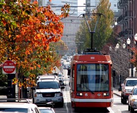 a head-on view of a red streetcar in Portland, Oregon, to illustrate an article about federal transportation funding.