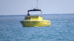 photo of a yellow rescue boat, surrounded by blue water, to illustrate article on "rethinking the rescue"