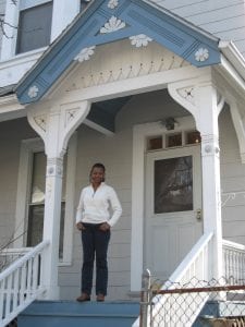 photo shows Roslyn George on the front porch of her home, purchased with the help of the Massachusetts Affordable Housing Alliance