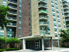 Photo of Starrett City, showing entrance to a brown and tan building with a portico over it. The photo shows about seven stories of the building; it extends beyond the frame of the photo.