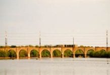 An orange tinted bridge over water in New Brunswick, New Jersey.