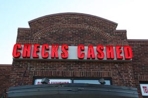 photo shows neon sign of a check-cashing store, to illustrate article about the H+T Index
