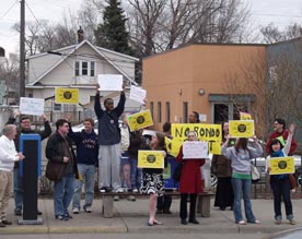 Image shows people at a 2008 rally to restore stops along a St. Paul light rail transit line.