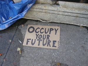 Occupy: Image shows cardboard sign reading "Occupy your Future"