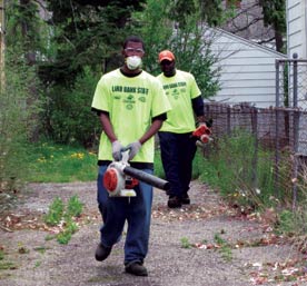 scattered-site rentals. Image shows two landscapers with leaf blowers