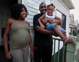 stabilizing urban neighborhoods. Image shows couple on front porch with young child