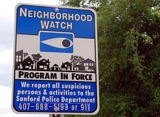 a street sign saying a neighborhood watch program is in force