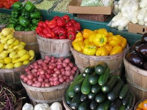 bushel baskets of fresh peppers, potatoes, squash, eggplant