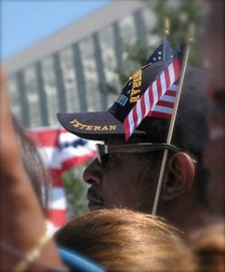 veterans. Image is ove veteran in bill cap holding small American flag