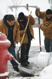 social impact investing: image shows men clearing snow around a fire hydrant