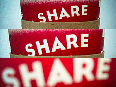 A red poster that says "Share" three times, each time getting larger and larger. The image signifies the sharing economy.