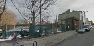 A fenced lot on a city street.