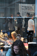 View of people on a sidewalk from inside a restaurant.