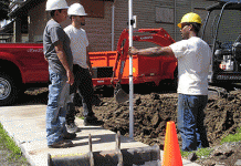 Members of an organization install pavement on a sidewalk in Buffalo, New York.