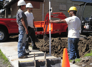 Members of an organization install pavement on a sidewalk in Buffalo, New York.