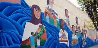 Mural on wall with faces of girls looking into the distance.