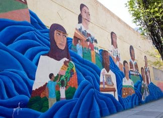 Mural on wall with faces of girls looking into the distance.