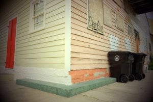 One home’s freshly renovated facade is juxtaposed by a badly burned side in the rapidly gentrifying Marigny neighborhood in New Orleans. The renovated side shows the hallmarks of gentrification, including sans-serif address numerals and a blood red door.