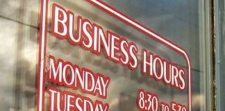Business Hours sign on glass door.