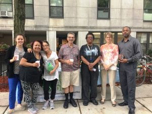 A group of residents who live in Boston hold their coffees as they pose for a photograph.