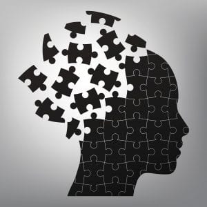 A black and white illustration of a head broken into puzzle pieces.