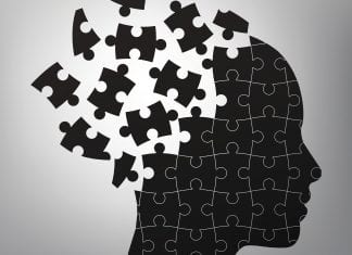 A black and white illustration of a head broken into puzzle pieces.
