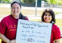 Two woman hold a sign that reads, "Pedagogy of the Oppressed Taught me ..."