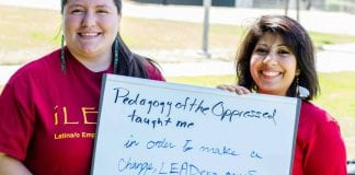 Two woman hold a sign that reads, "Pedagogy of the Oppressed Taught me ..."