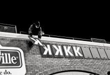 Man places strikeout symbols on baseball stadium wall.