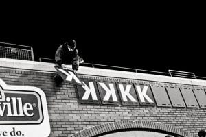 Man places strikeout symbols on baseball stadium wall.