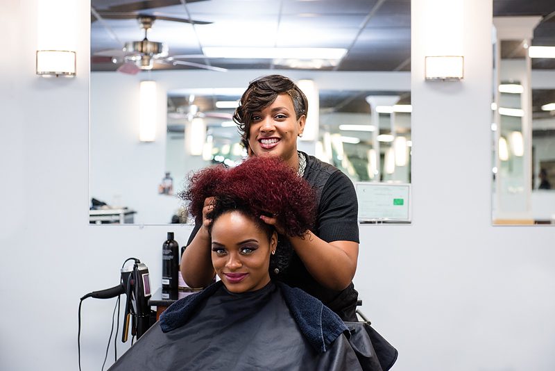 A stylist at a salon works on another woman's hair at a salon in North Carolina. The business, Essence of Beauty, secured a loan thanks to the help of a CDFI.