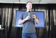 Mark Zuckerberg, founder of Facebook, speaking and holding a microphone.