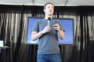 Mark Zuckerberg speaking and holding a microphone.