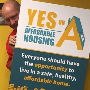 Chris Wilder, Valley Medical Center Foundation CEO, holds a sign that reads "Yes on A: Affordable Housing. Everyone should have the opportunity to live in a safe, healthy, affordable home." The initiative tied health and housing funding for county residents.