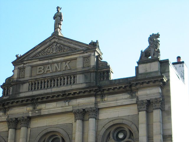The spires and statue atop an old bank building.