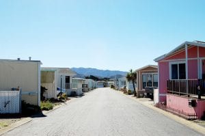 Row of trailer homes with mountains in the background.