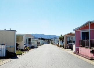 Row of trailer homes with mountains in the background.