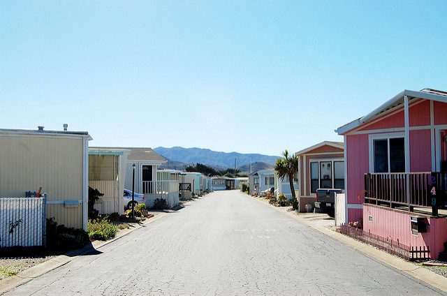 Row of trailer homes with mountains in the background.