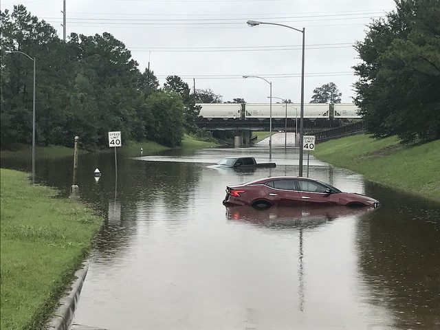 A car and truck submerged on a flooded road.