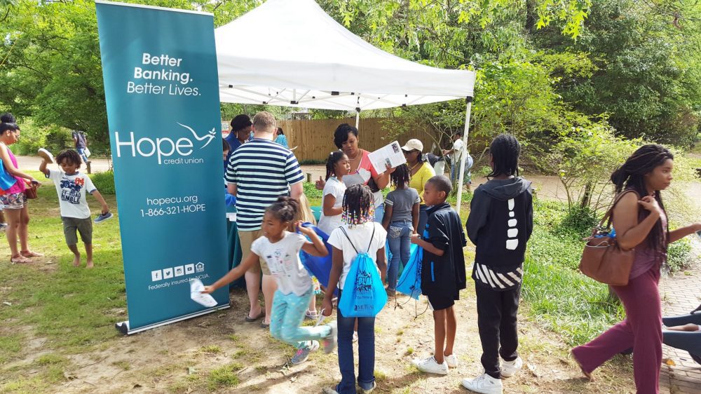 people gathered under and around an information tent