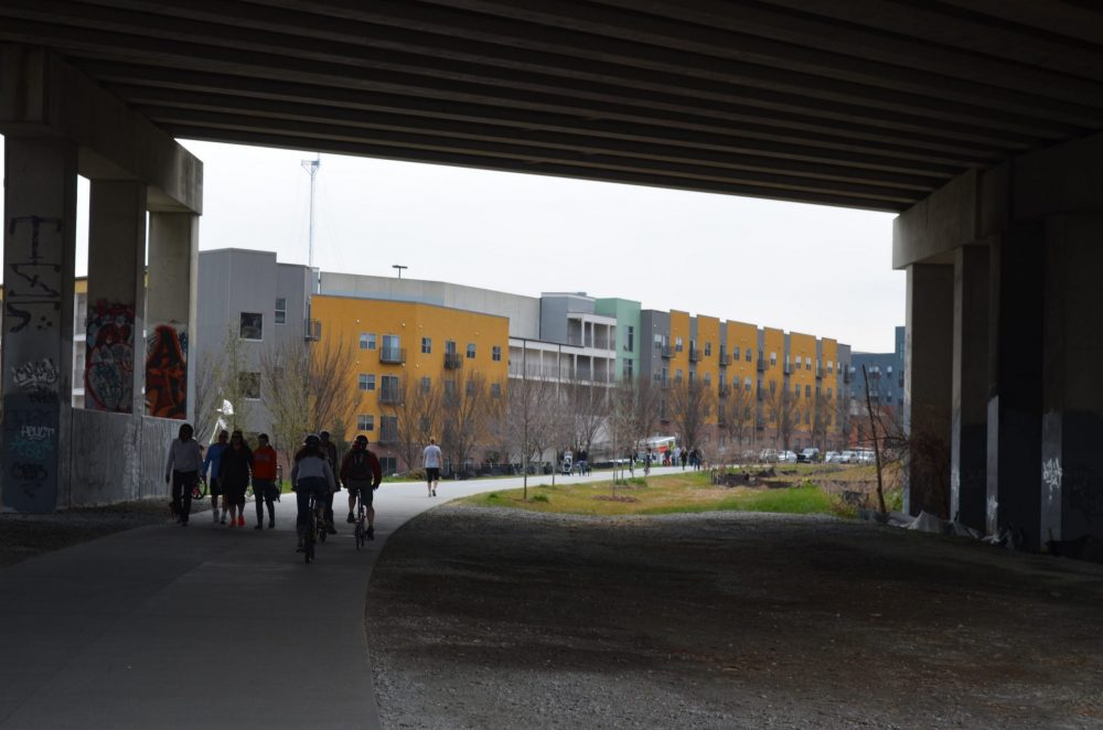 Pedestrians and bicyclists are shown on the left with new development in the background along the Atlanta Beltline.