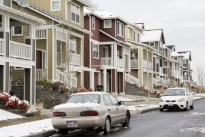 A line of homes in Seattle, Washington. Two cars are also shown.