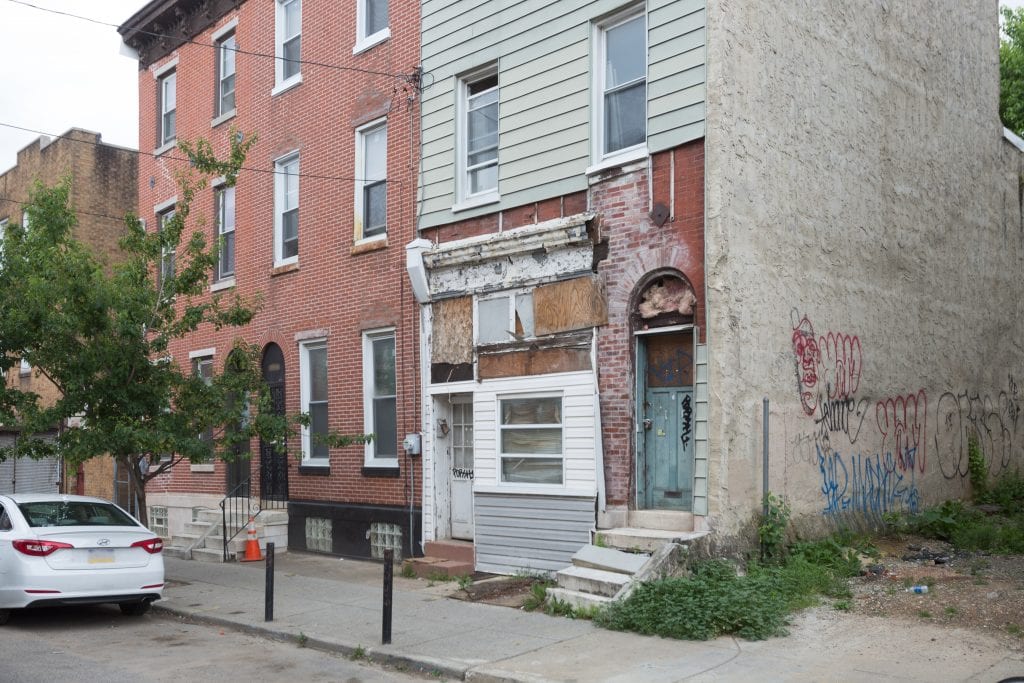 An exterior view of a rowhouse in Philadelphia, Pennslyvania that appears to have some water damage and needs repairs.