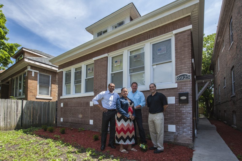 A group of people stand in front of a Chicago home that was rehabbed.