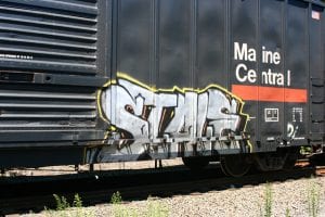 Word "stale" spray-painted on side of train car.