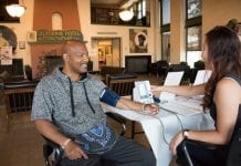 An African-American man gets his blood pressure checked at the California Hotel, an EBALDC development that offers affordable apartments with community and commercial spaces.