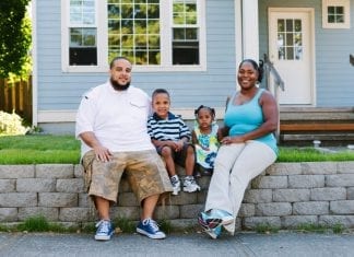 A family of four sit outside their home in Portland. Portland's preference policy gives priority for homeownership opportunities funded by the city’s housing bureau to residents who were displaced.