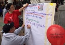 Two people write down thoughts about what they think Chinatown's future should be.